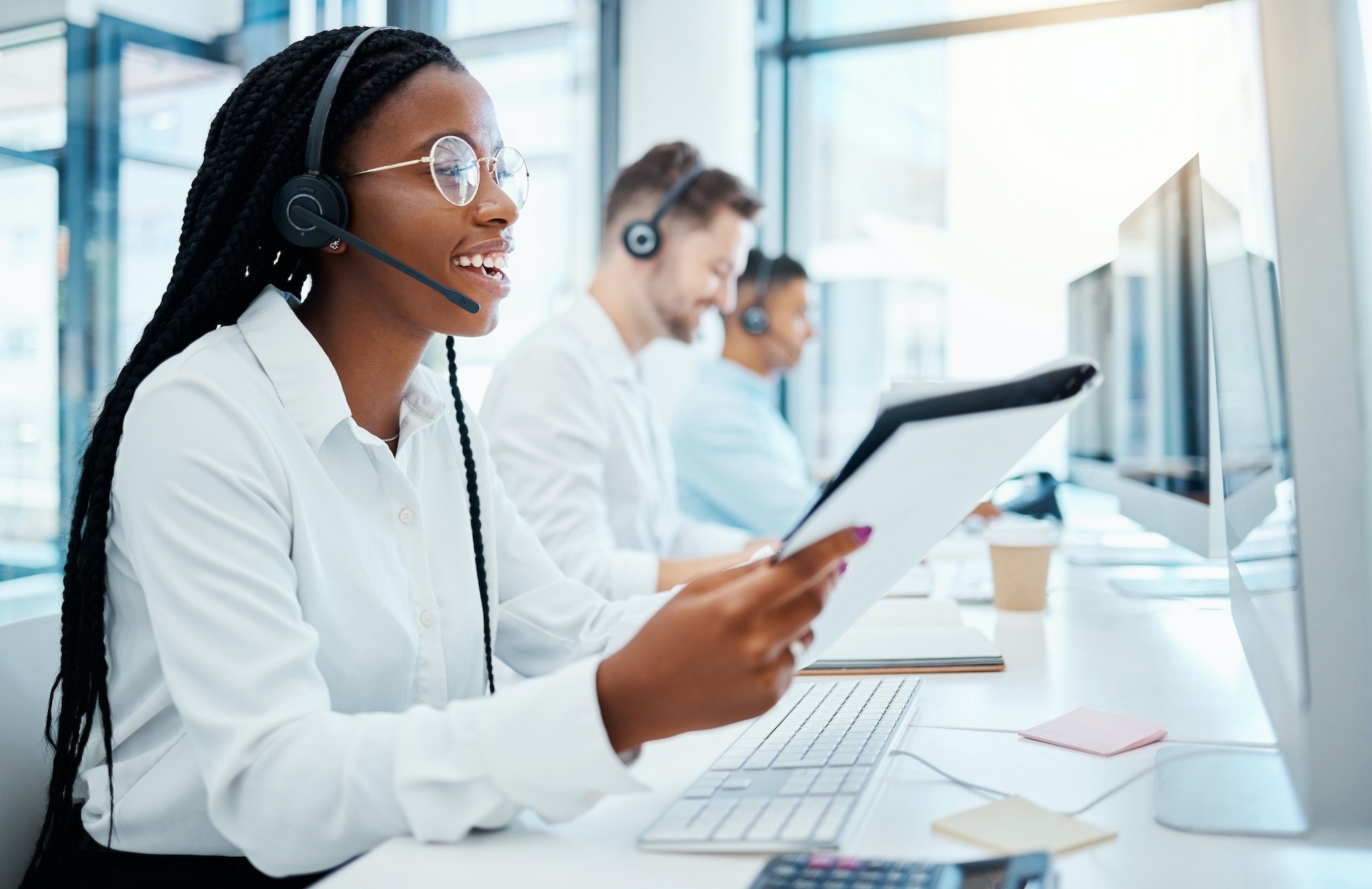 contact-us-customer-support-and-happy-call-center-consultant-working-in-office-smiling-while-help